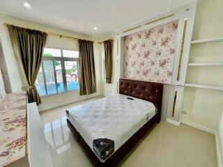 Bright and clean bedroom with floral wallpaper and large windows