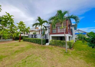 exterior view of a house with a garden and palm trees