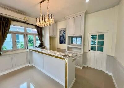 Modern kitchen with chandelier and large windows