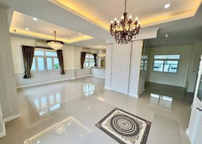 Spacious and elegant living room with chandeliers and large windows