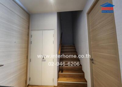 Hallway with wooden stairs leading to the upper floor