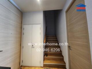 Hallway with wooden stairs leading to the upper floor
