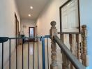 Well-lit corridor with wooden stair railing and baby gate