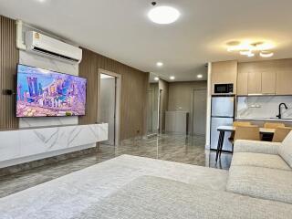 Modern living room and kitchen area with contemporary furniture and appliances