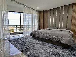 Modern bedroom with large windows and city view