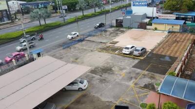Aerial view of a parking area with several parked cars adjacent to a main road