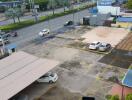 Aerial view of a parking area with several parked cars adjacent to a main road