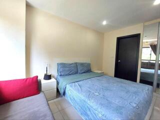 Cozy bedroom with double bed, nightstand, and mirrored wardrobe