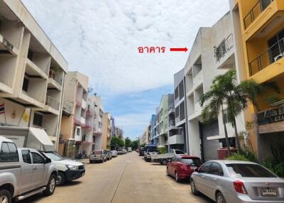 Street view of a residential area with multiple buildings and parked cars