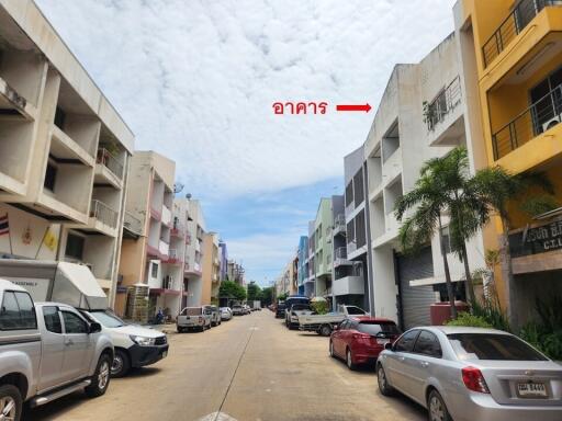 Street view of a residential area with multiple buildings and parked cars