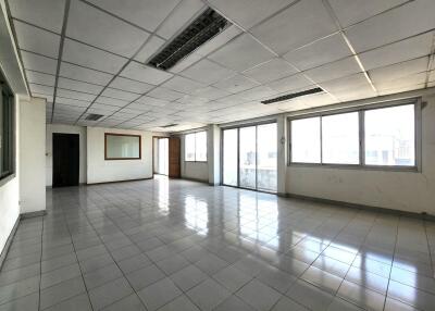 Spacious empty room with tiled floor and large windows