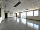 Spacious empty room with tiled floor and large windows