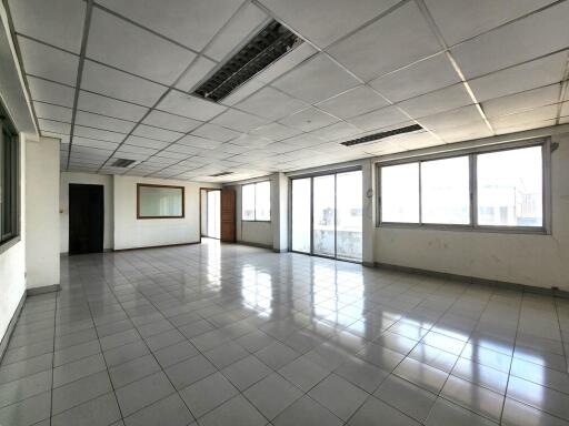 Spacious empty room with tiled floor and large windows