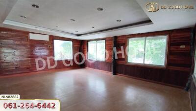 Spacious room with wooden wall panels and large windows