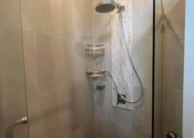 Shower area with glass door and tiled walls