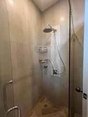 Shower area with glass door and tiled walls