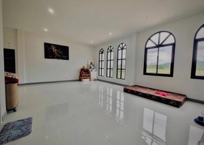Spacious living room with large windows and glossy floor tiles