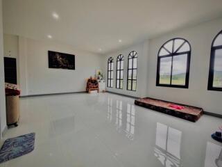 Spacious living room with large windows and glossy floor tiles