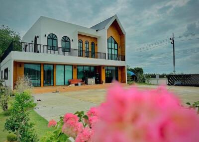 Modern two-story house with large windows and upper balcony