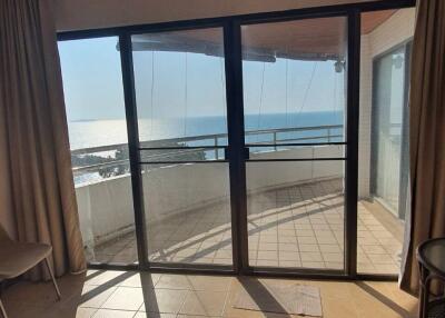 Living area with sliding glass doors leading to a balcony with an ocean view