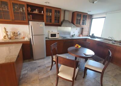 Modern kitchen with wooden cabinets, dining table, and appliances