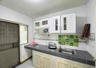 Simple kitchen with white cabinets and green tiled backsplash