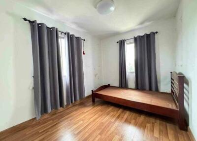 Bedroom with wooden flooring, bed frame and curtains