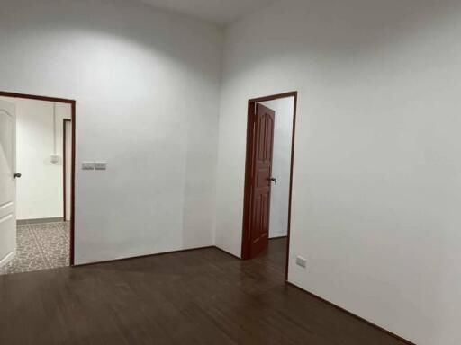 Minimalist room with wooden floor and two doorways