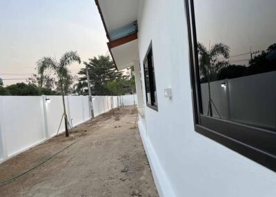 Side exterior view of a house with white walls and a garden space