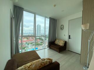 Spacious living room with large windows and city views