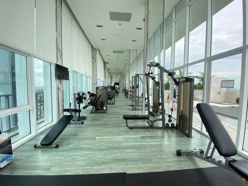 Modern gym with a variety of exercise equipment and large windows