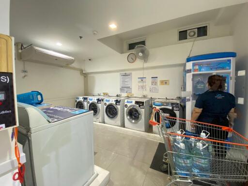 Laundry room with washing machines, water dispenser, and customer