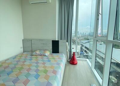 Modern bedroom with a large window offering a city view