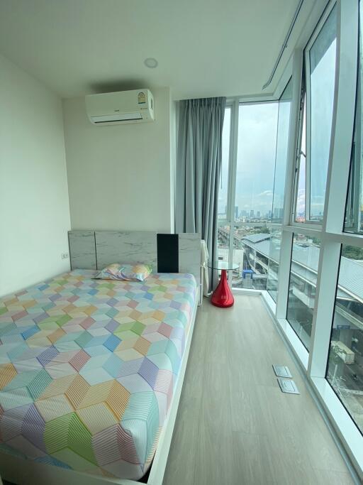 Modern bedroom with a large window offering a city view