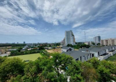 View of surrounding area with high-rise buildings, greenery, and construction activity