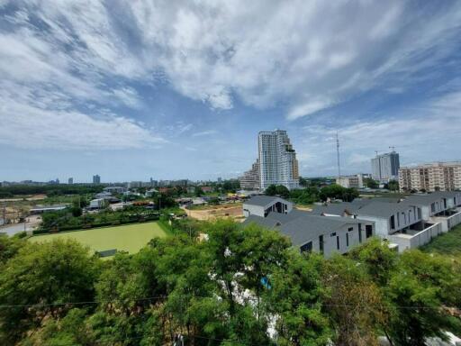 View of surrounding area with high-rise buildings, greenery, and construction activity