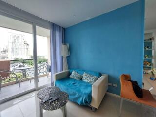 Cozy living area with a blue accent wall and access to a balcony