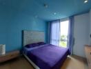 Modern bedroom with blue walls and purple bedding