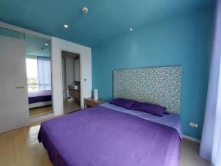 Bedroom with blue walls and purple bedding