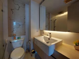 Modern bathroom with toilet, sink, large mirror, and shower