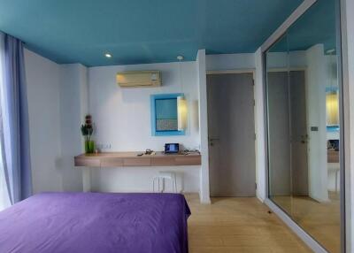 Modern bedroom with blue ceiling and large mirrored wardrobe