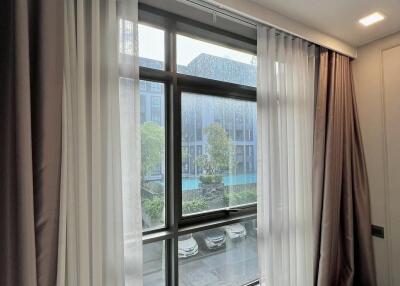 Bedroom window with curtains and a view of an outside parking area
