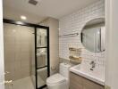Modern bathroom with glass shower, round mirror, and elegant fixtures