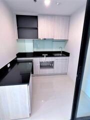 Modern kitchen with black countertops and light wood cabinetry