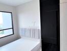 Modern bedroom with large window and built-in wardrobe