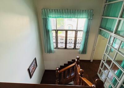 View of staircase with wooden railing and window