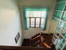 View of staircase with wooden railing and window