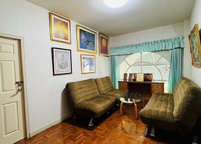 Cozy living room with framed art and green sofas