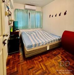 Bedroom with a double bed, air conditioning, and wooden flooring
