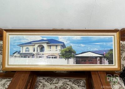Framed photo of a house placed against a wall